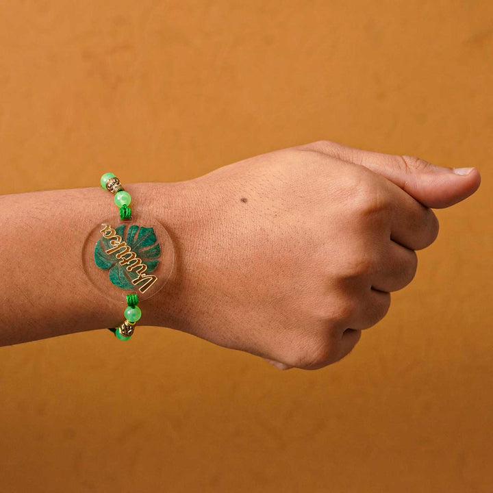 Personalized Handmade Leaf Acrylic Rakhi With Roli Chawal - Worn on Wrist Close-up