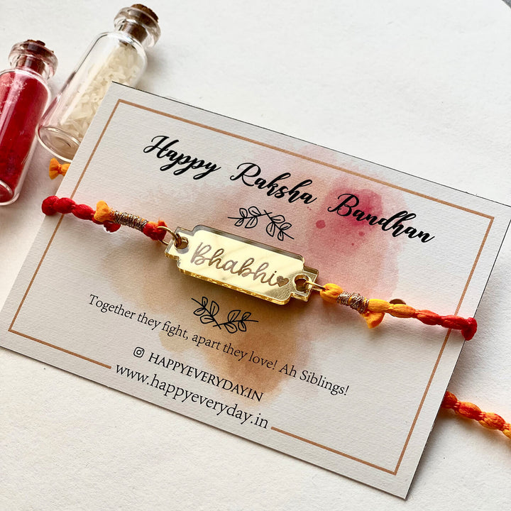 Handcrafted Golden Acrylic Rakhi With Roli Chawal 1 - Front View on Card