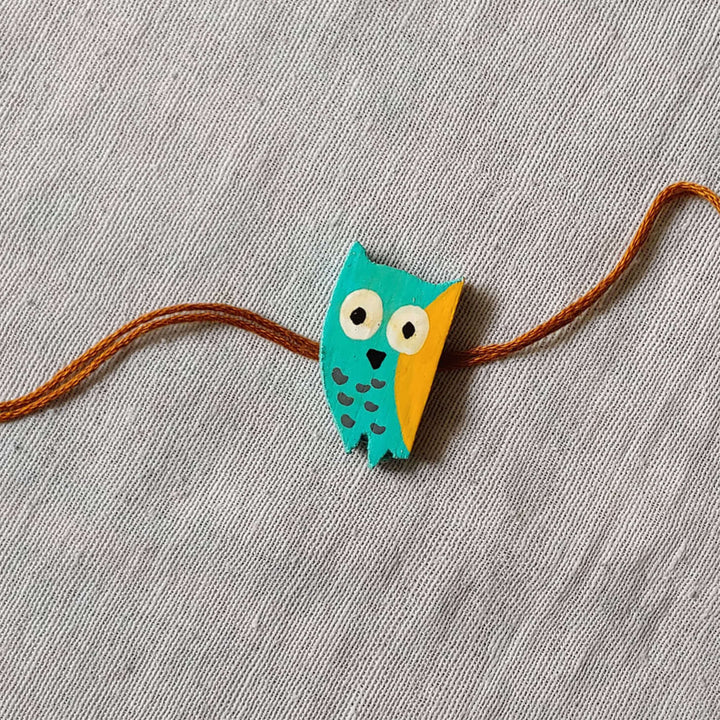 Handpainted Quirky Wooden Rakhi With Roli Chawal 2 - Close-up of Owl Rakhi