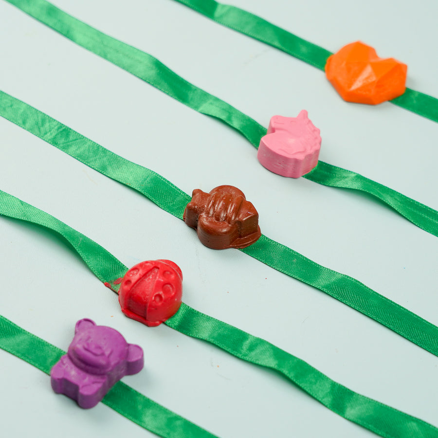 Reusable Non Toxic Girls Theme Wax Kids Rakhi Set Of 5 - Close-up of Charms on Green Ribbon