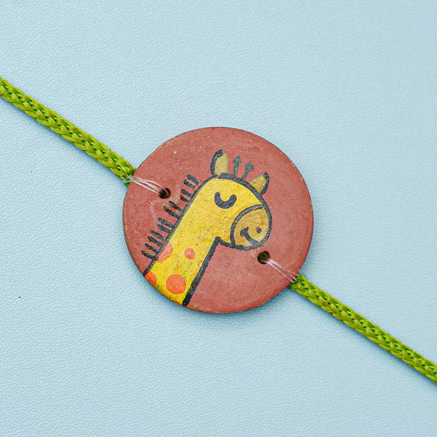 Personalized Animal Theme Terracotta Rakhi With Roli Chawal For Kids 6 - Close-up of Giraffe Design