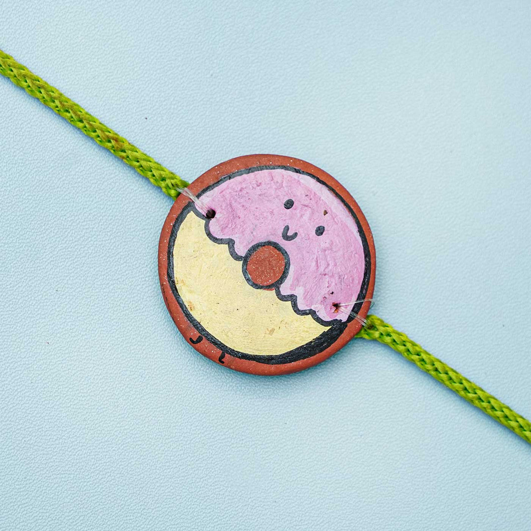 Hand Painted Donut Theme Terracotta Rakhi With Roli Chawal - Close-up of Donut Charm