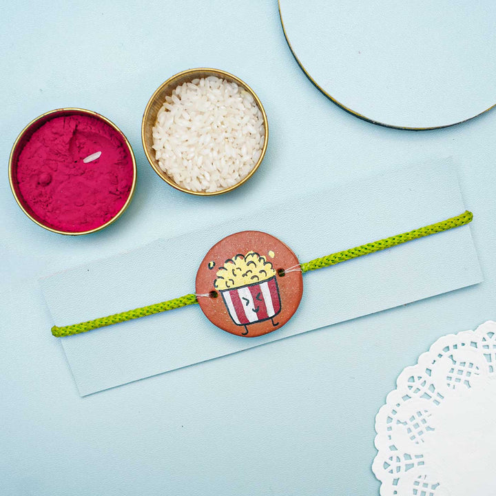 Hand Painted Terracotta Rakhi With Roli Chawal - Styled Product Display with Accessories