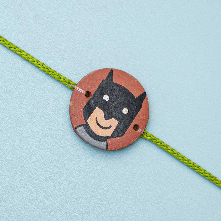 Hand Painted Batman Terracotta Rakhi With Roli Chawal For Kids - Close-up of Charm Detail
