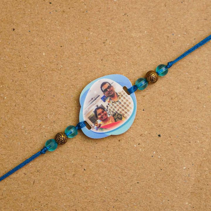 Photo Personalized Handmade Photo Acrylic Rakhi With Roli Chawal - Close-up of blue photo rakhi