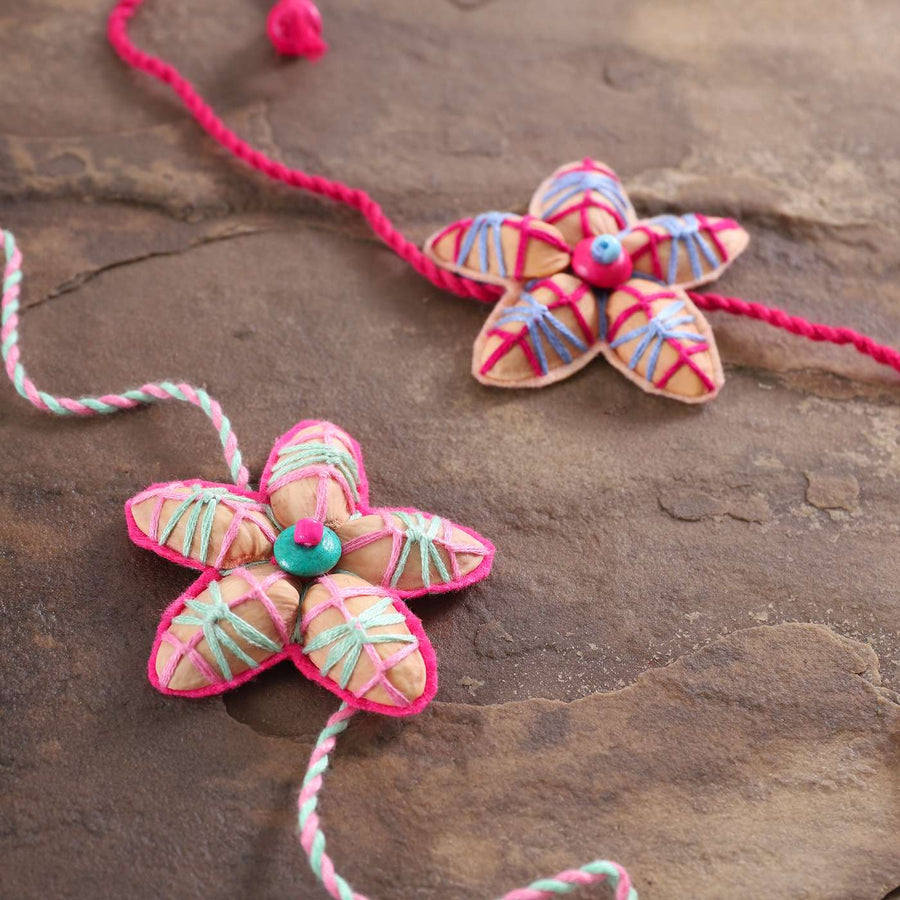 Handmade Beaded Pista Shell Rakhi With Roli Chawal Set Of 2 - Close-up of Flower Charms