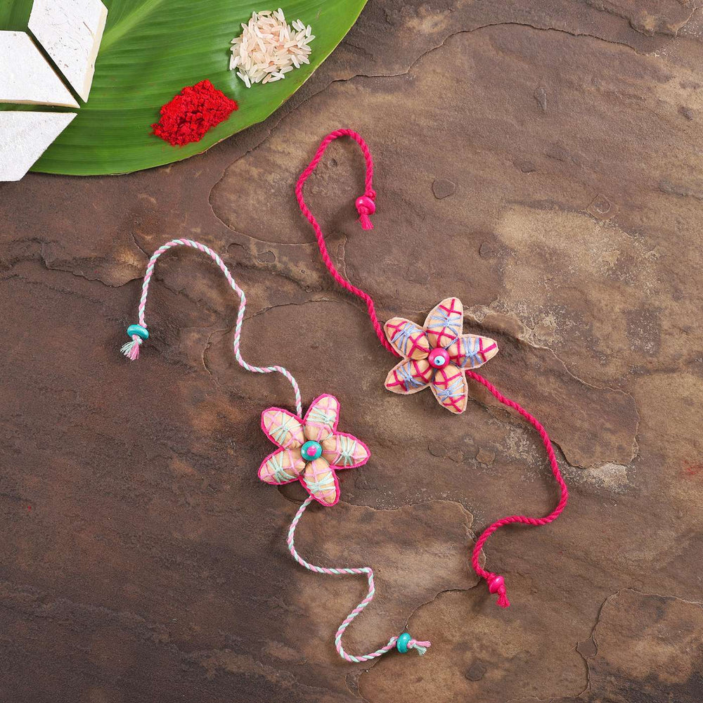 Handmade Beaded Pista Shell Rakhi With Roli Chawal Set Of 2 - Full View with Green Leaf Props