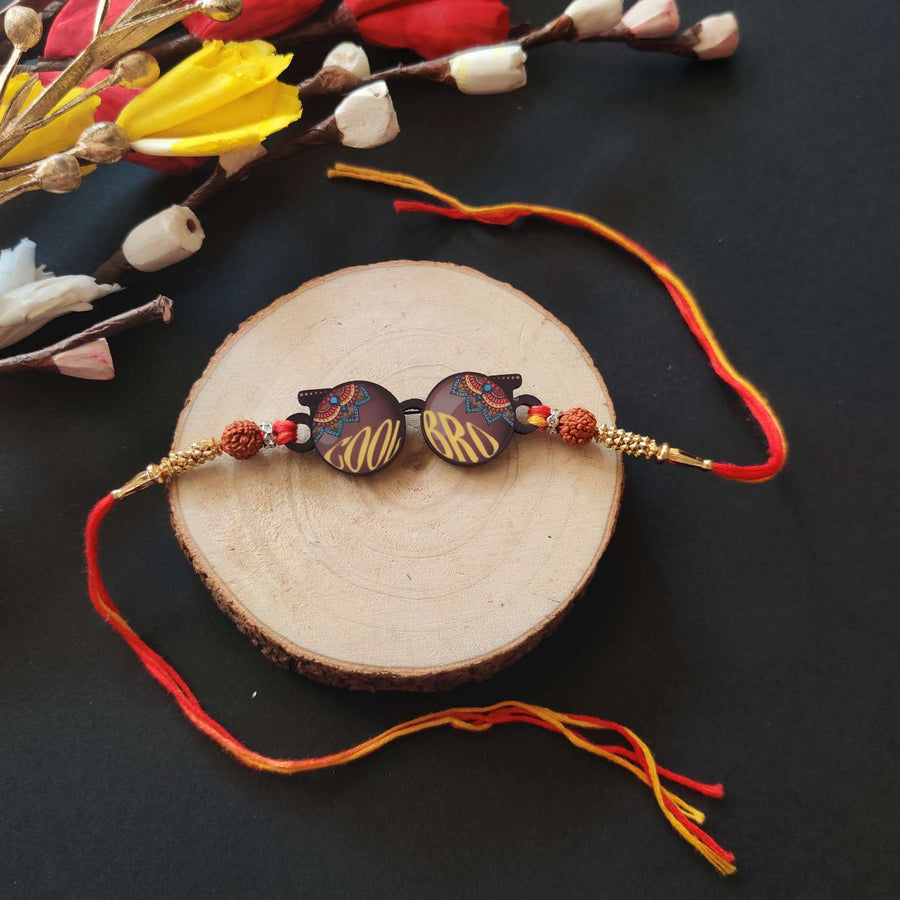 Handmade Printed Cool Bro Wooden Rudraksha Rakhi With Roli Chawal - Flat Lay on Wood Slice