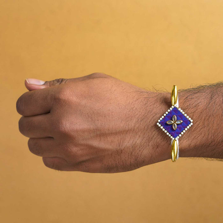 Handmade Purple Diamond Fabric And Mdf Rakhi With Roli Chawal - On wrist display