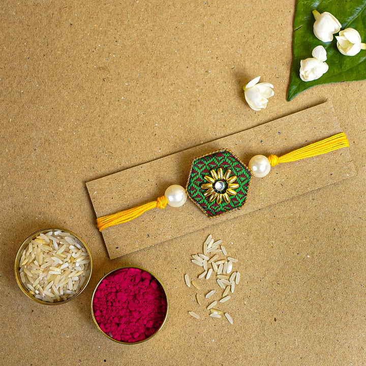 Handmade Green Hexagon Fabric And Mdf Rakhi With Roli Chawal - Flat Lay with Rakhi and Accessories