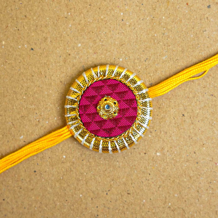 Handmade Maroon And Yellow Round Fabric And Mdf Rakhi With Roli Chawal - Close-up of Rakhi Design