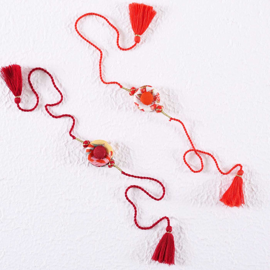 Handmade Ring Cotton Rakhi With Roli Chawal Set Of 2 - Flat Lay on Textured White Background