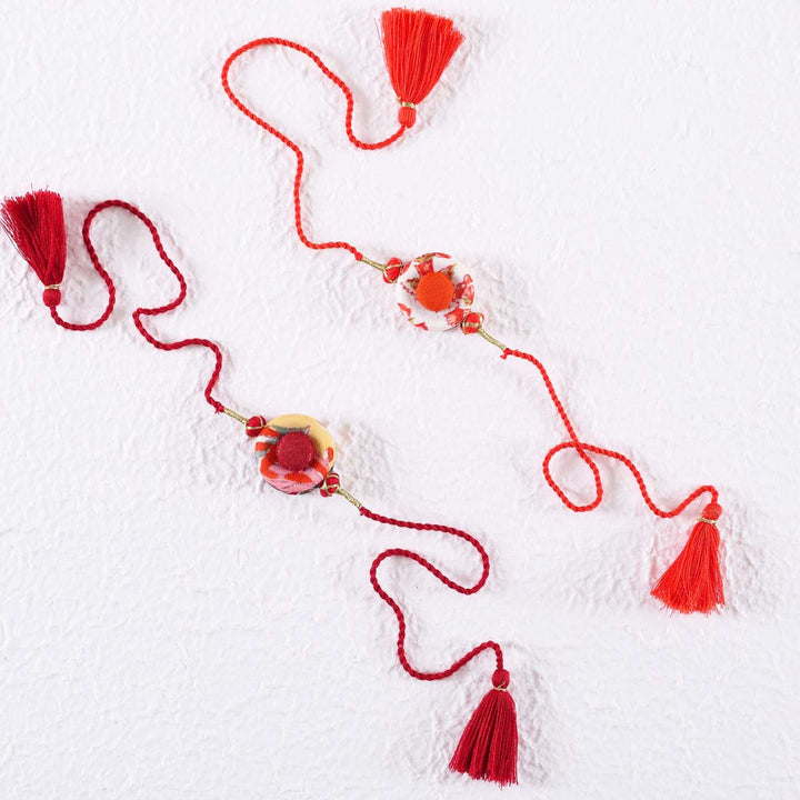 Handmade Ring Cotton Rakhi With Roli Chawal Set Of 2 - Flat Lay on Textured White Background