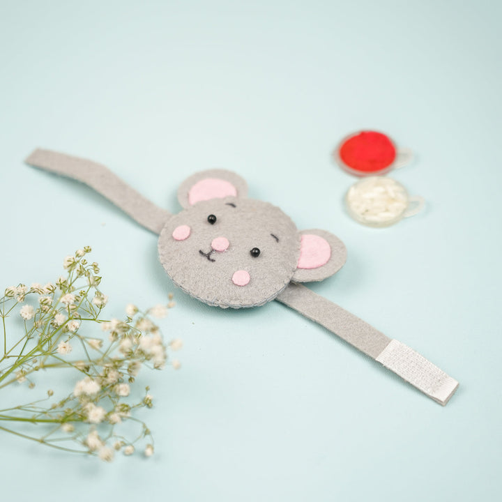 Handmade Koala Theme Felt Kids Rakhi With Roli Chawal - Flat Lay with Decorative Spools and Flowers