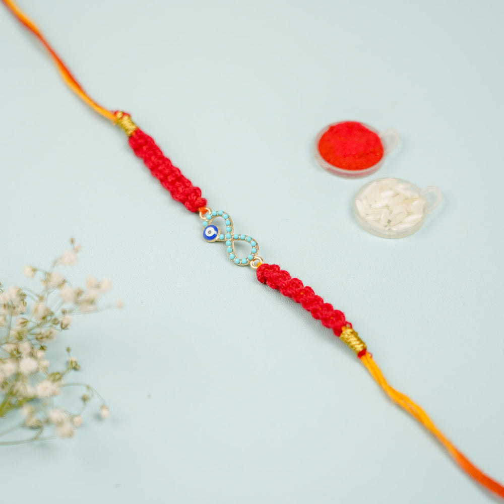 Handmade Macrame Infinity Evil Eye Metal Rakhi With Roli Chawal - Styled View with Decorative Items