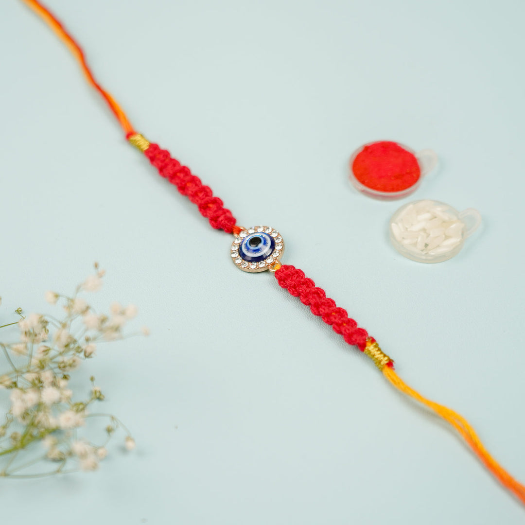 Handmade Macrame Circle Evil Eye Metal Rakhi With Roli Chawal - Flat Lay View with Decorative Items