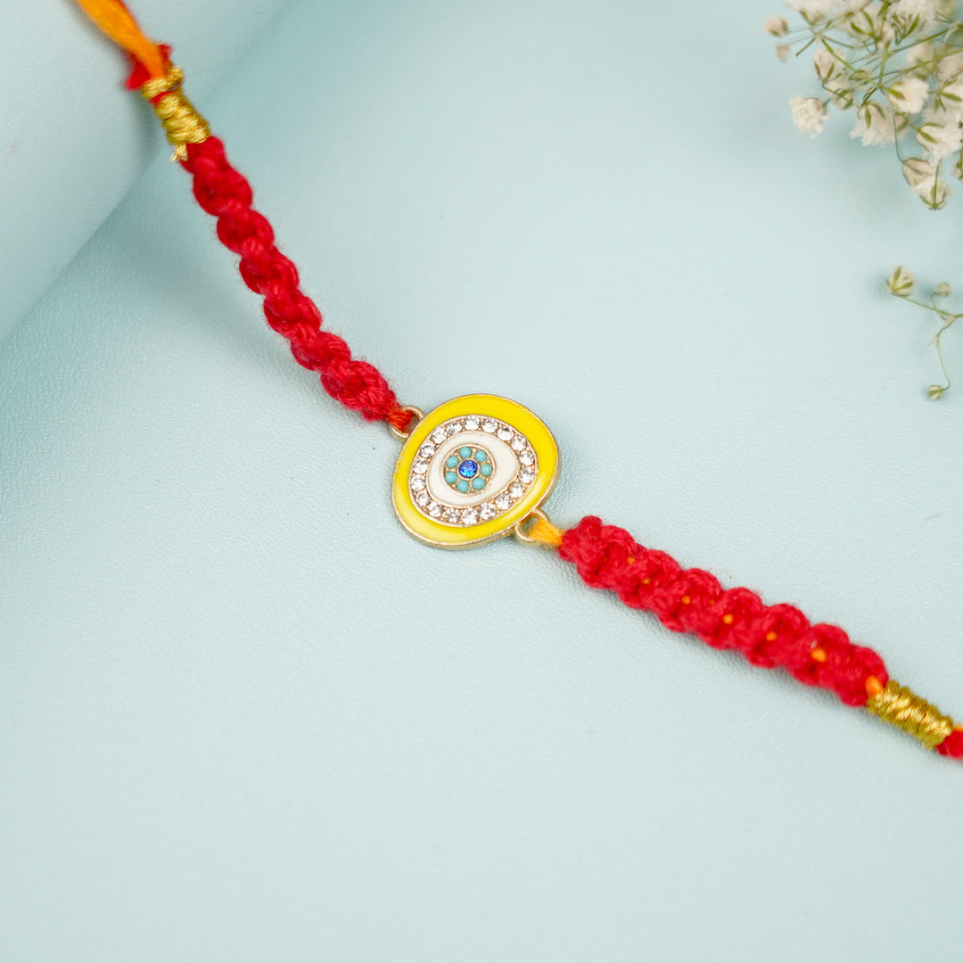 Customized Handmade Macrame Evil Eye Metal Rakhi With Roli Chawal - Close-up showing charm detail