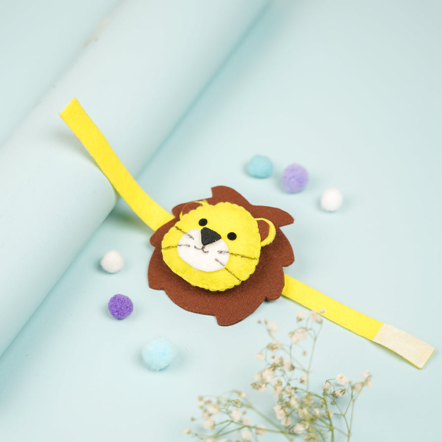 Handmade Lion Theme Felt Kids Rakhi With Roli Chawal 2 - Front View with Decorative Pom Poms