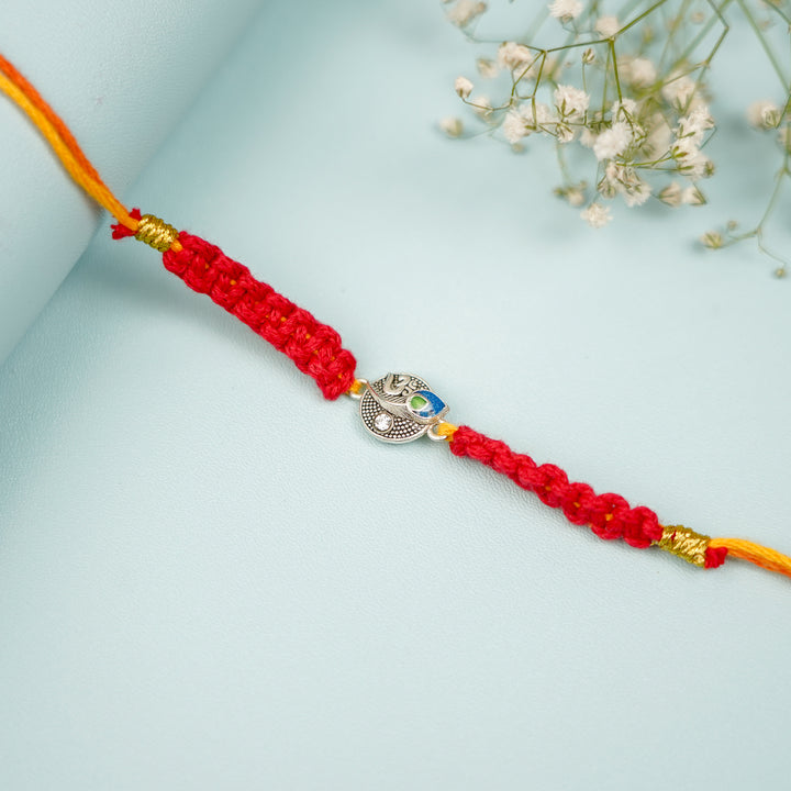 Handmade Macrame Religious Om Theme Metal Rakhi With Roli Chawal - Close-up of Bracelet Design