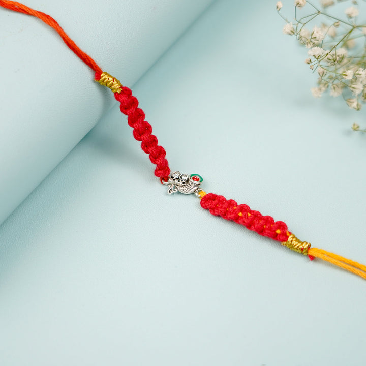 Handmade Macrame Silver Peacock Theme Metal Rakhi With Roli Chawal - Close-up of knot and charm