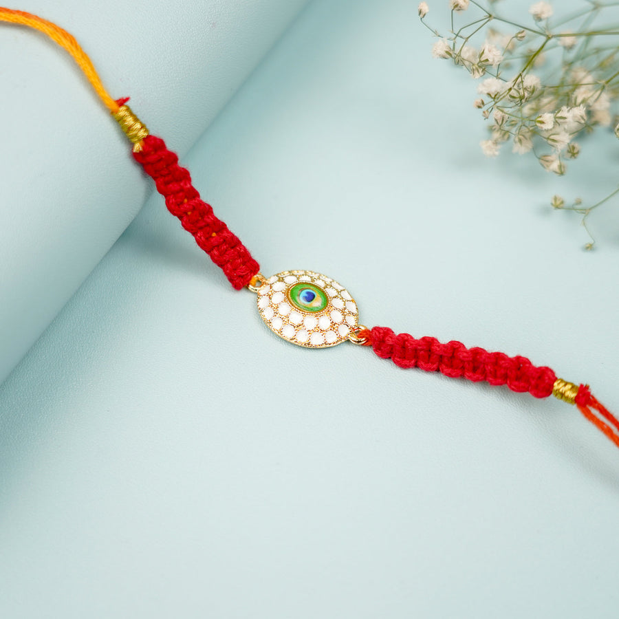 Handmade Macrame Oval Peacock Feather Theme Metal Rakhi With Roli Chawal - Close-up of Main Design