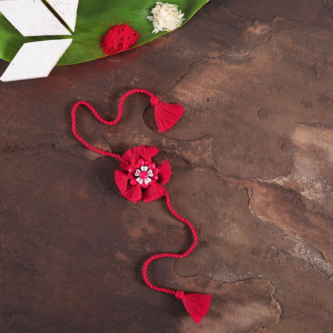 Handmade Beaded Tassel Flower Cotton Rakhi With Roli Chawal 1 - Styled flat lay with decoration elements