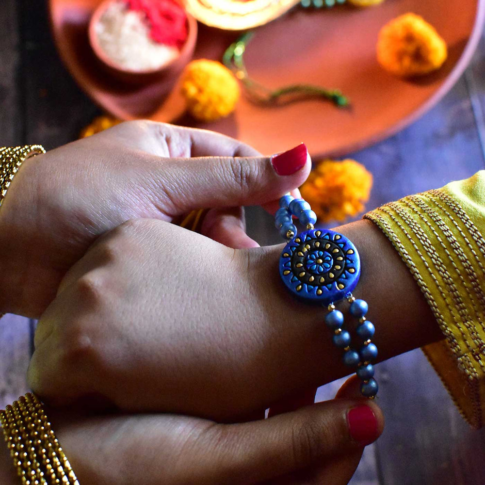 Handmade Ecofriendly Round Terracotta Rakhi With Roli Chawal - On Wrist Close-up View