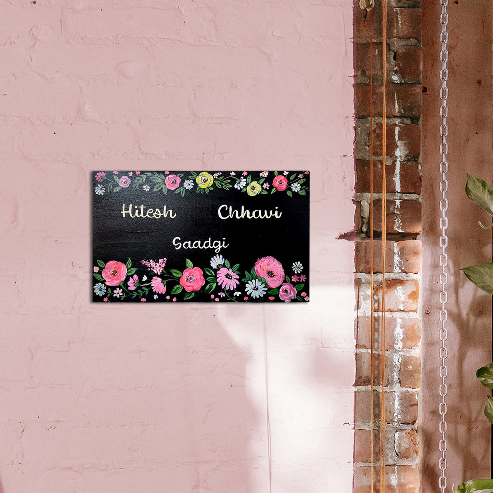 Personalised Floral Design Family Chalkboard Name Plate - Mounted on Pink Brick Wall
