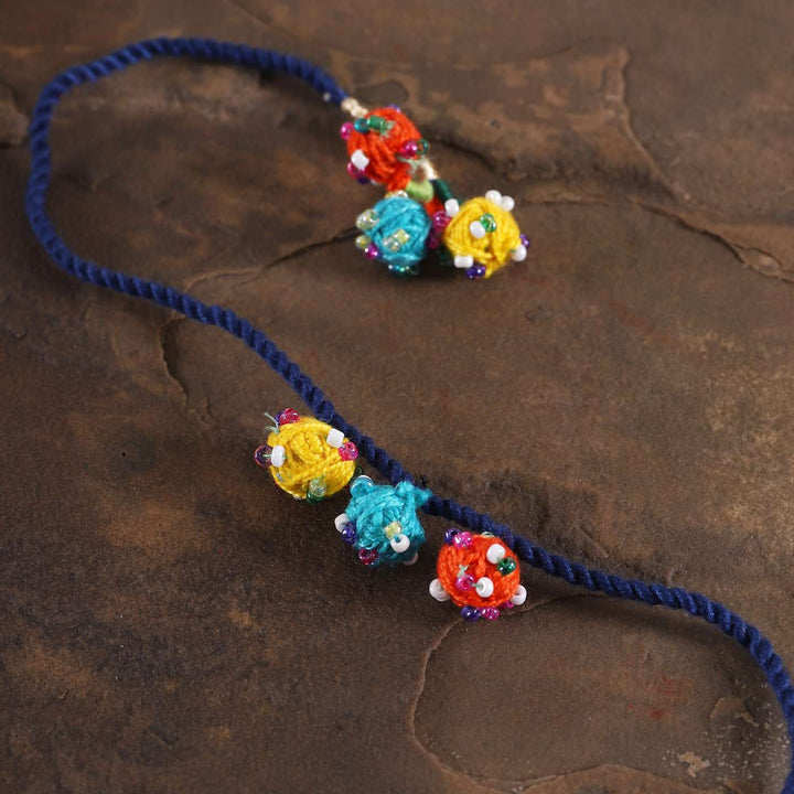 Handmade Beaded Dark Blue Dori Rakhi With Roli Chawal - Close-up of decorative elements