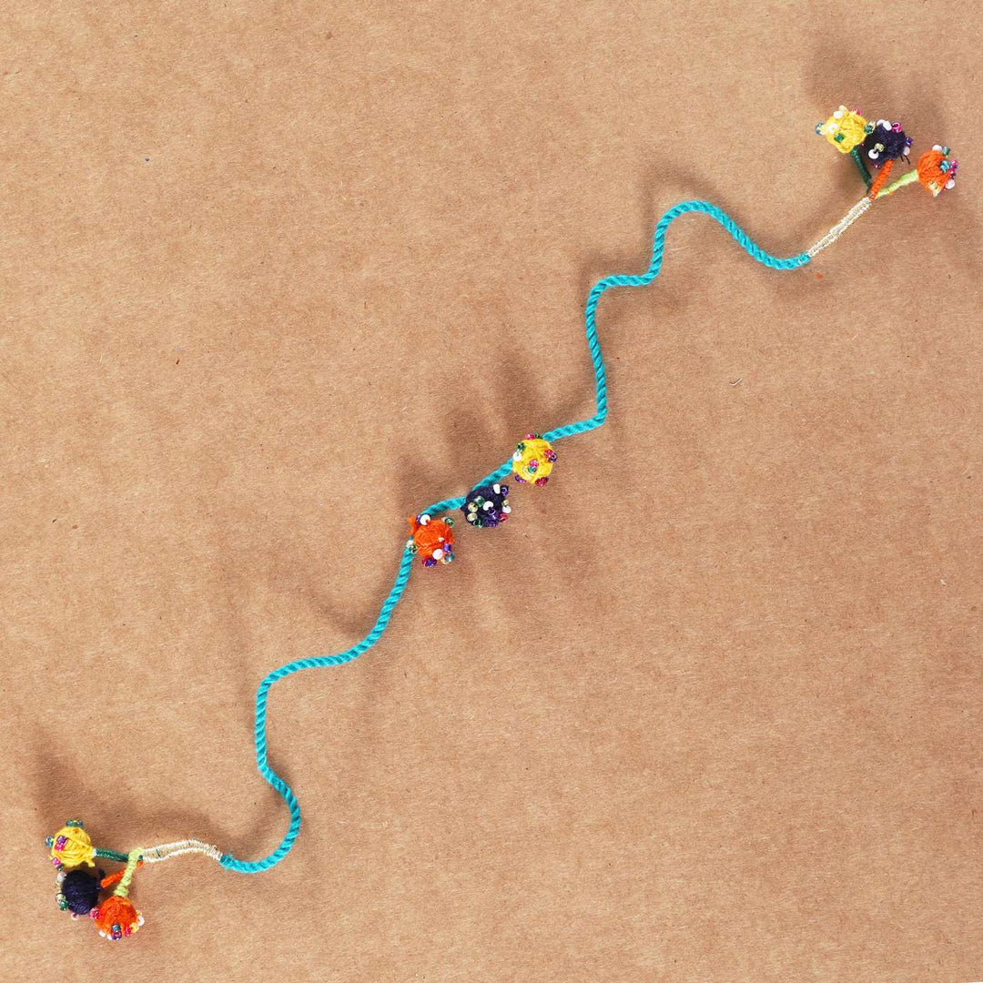 Handmade Beaded Light Blue Dori Rakhi With Roli Chawal - Full Length View on Plain Background