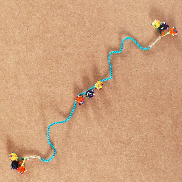 Handmade Beaded Light Blue Dori Rakhi With Roli Chawal - Full Length View on Plain Background