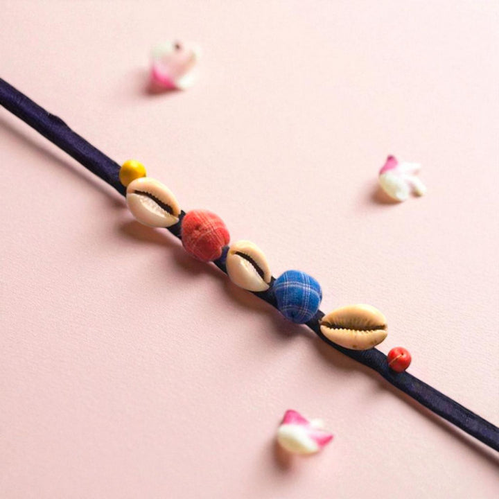 Handmade Beaded Shell Design Upcycled Fabric Rakhi With Roli Chawal For Brother - Diagonal view with shells and beads