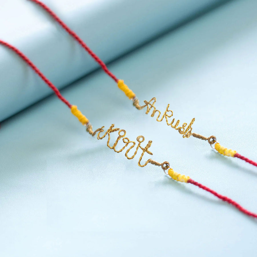 Personalized Brass Lettering Bhaiya Bhabhi Rakhi Set With Roli Chawal Set Of 2 - Close-up of personalized wire nameplates
