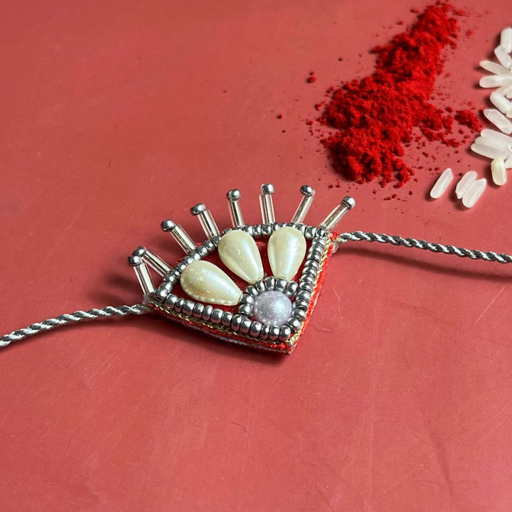 Handmade Beaded Paw Silver Rakhi With Roli Chawal - Decorative Rakhi thread close-up