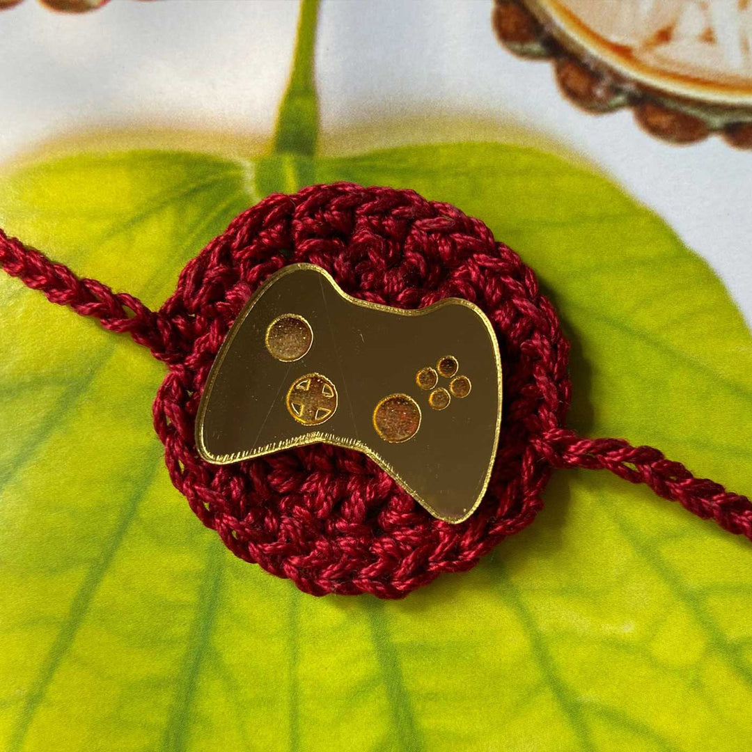 Handmade Crochet Joystick Theme Cotton Rakhi With Roli Chawal - Close-up of Game Controller Charm