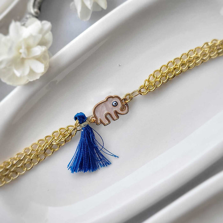 Handmade Elephant Design Bracelet Rakhi Hamper With Roli Chawal For Sisters - Close-up of bracelet with blue tassel