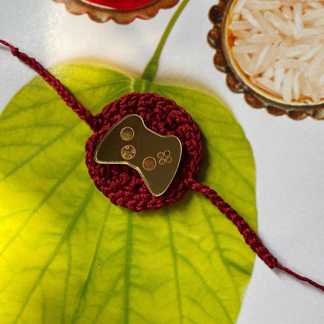 Handmade Crochet Joystick Theme Cotton Rakhi With Roli Chawal - Angled View with Controller Charm