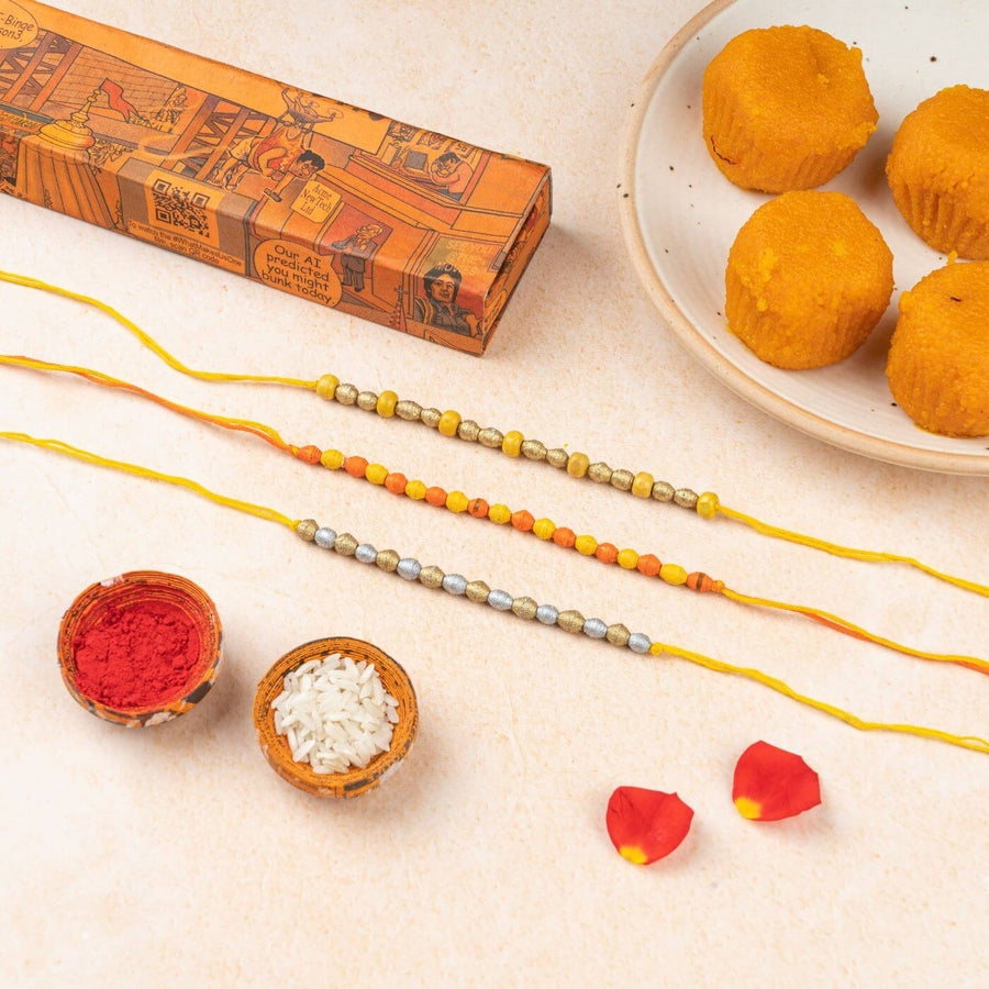 Handcrafted Paper Beads Rakhi Hamper With Rice Roli 3 - Rakhis and accessories flat lay