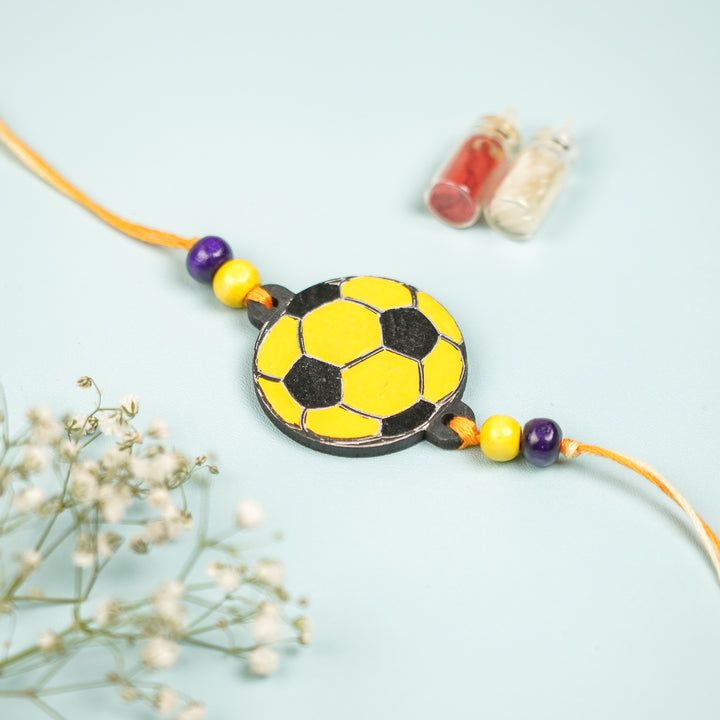Hand Painted Football Design Mdf Wood Kids Rakhi - Front View with Decorative Bottles