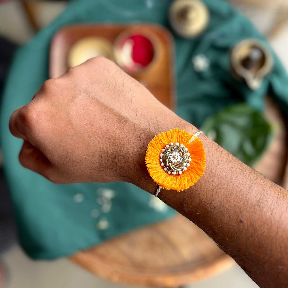 Handmade Zardozi Mustard And White Bead Work Rakhi With Wooden Box And Roli Chawal - Worn on wrist view