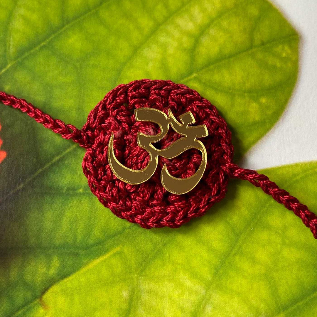 Handmade Crochet Religious Om Theme Cotton Rakhi With Roli Chawal - Close-up with Leaf Background