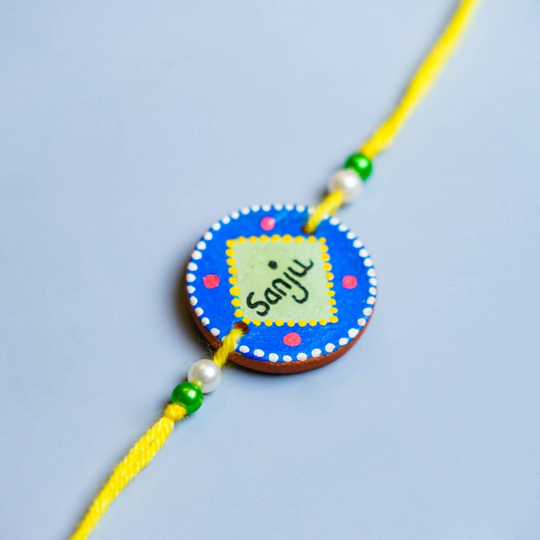 Personalized Best Sister Terracotta Mug And Rakhi Set - Rakhi Close-up Name Detail