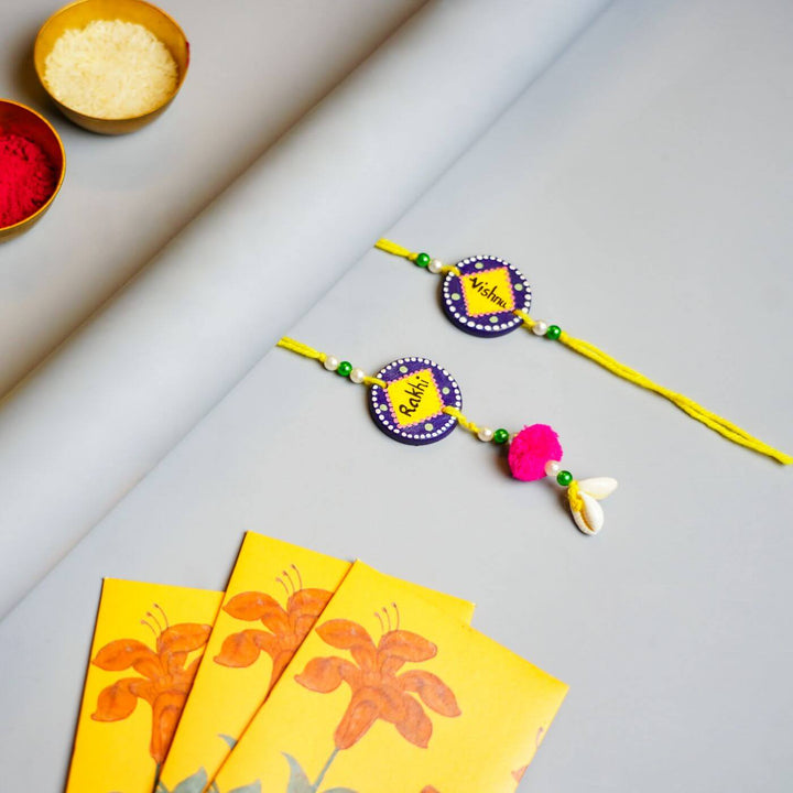 Personalized Terracotta Tumbler Rakhi Set With Caricature - Flat Lay with Rakhis and Color Powders