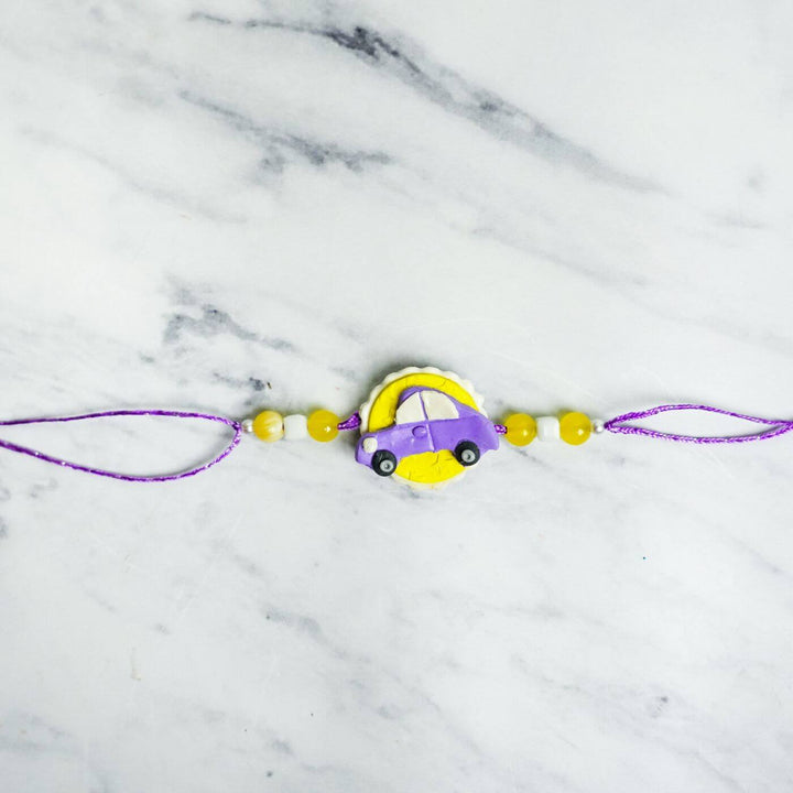 Handmade Porcelain Clay Themed Rakhi 9 - Flat Lay of Purple Car Rakhi