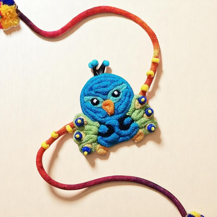 Handmade Dori Work Peacock Kids Rakhi With Roli Chawal - Close-up Front View