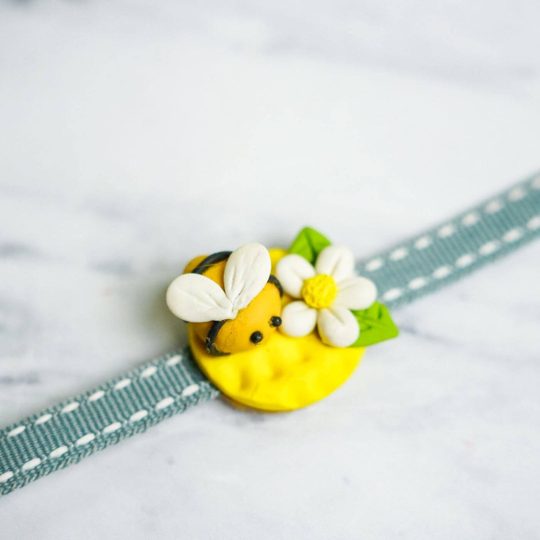 Handmade Porcelain Clay Themed Rakhi 7 - Close-up of bee charm