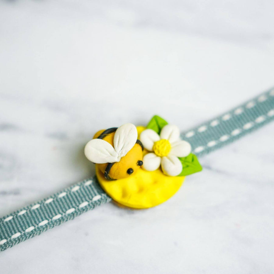 Handmade Porcelain Clay Themed Rakhi 7 - Close-up of bee charm