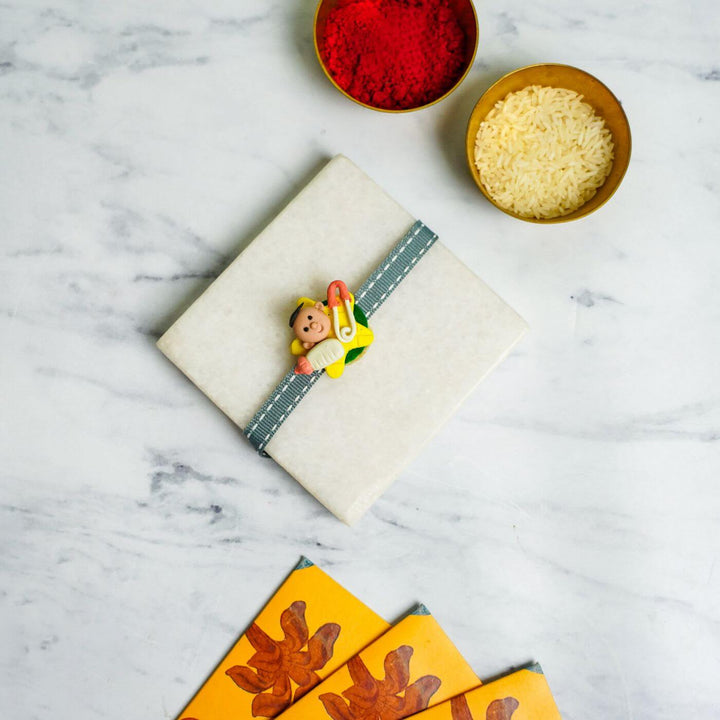 Handmade Porcelain Clay Themed Rakhi 12 - Wrapped Gift with Rakhi Styling