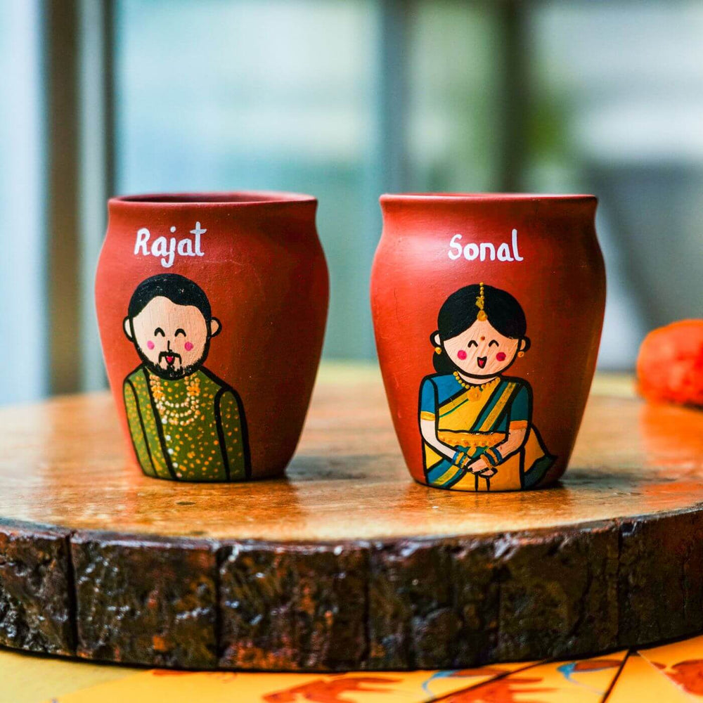 Personalized Terracotta Kulhad Rakhi Set With Caricature - Close-up of Painted Clay Mugs