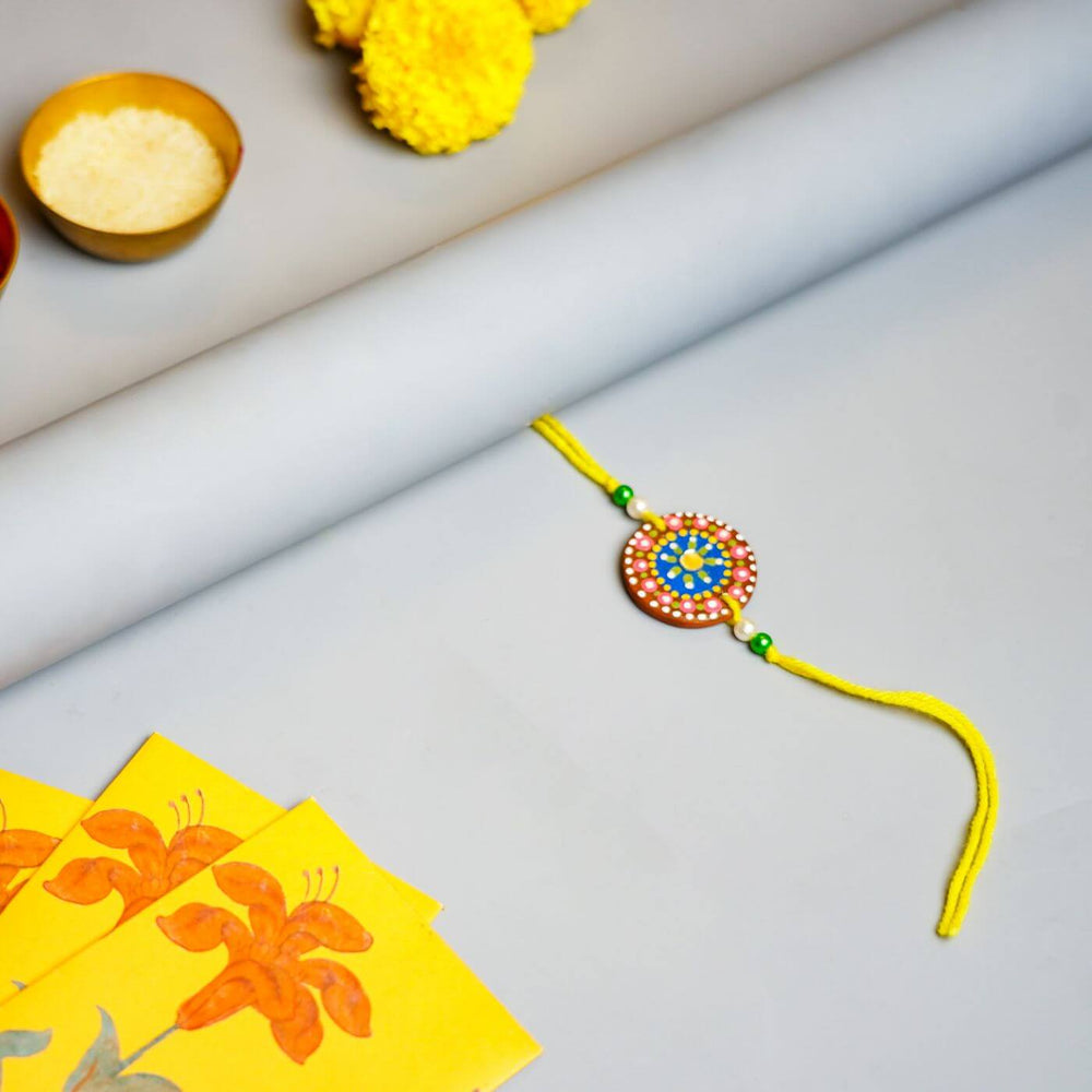 Handpainted Terracotta Rakhi Mug Set With Roli Chawal - Flat lay with ceremonial items